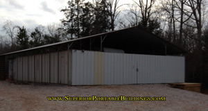 Barn roof covering three tractor trailer shipping containers.