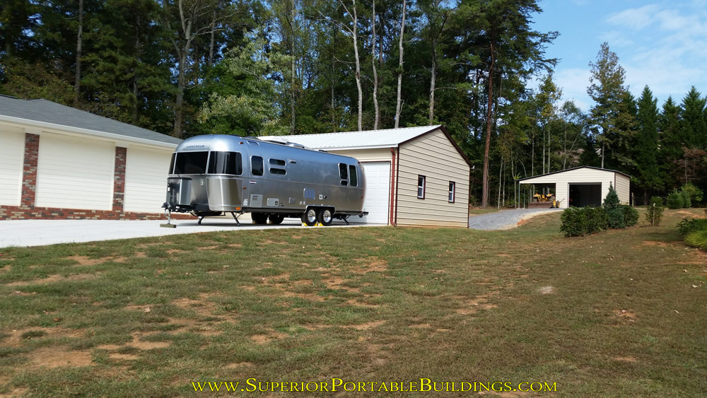 Air stream camper and 2nd steel garage with lean to.